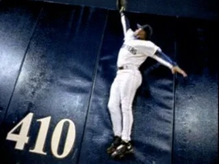 Seattle Mariners baseball campaign featuring Ken Griffey Jr. leaping at the 410 mark on the outfield wall