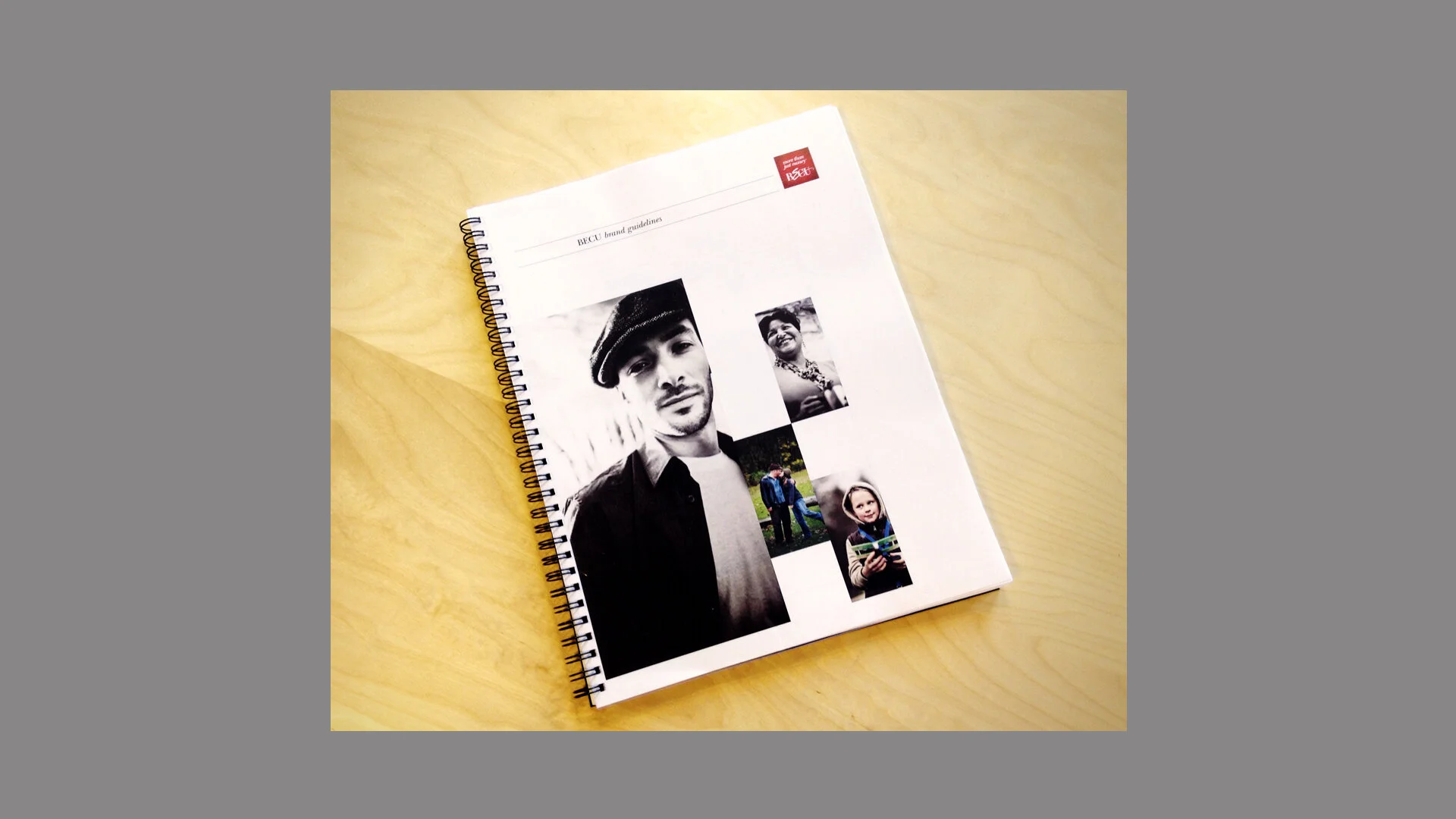 BECU brand guidelines booklet on a wooden desk