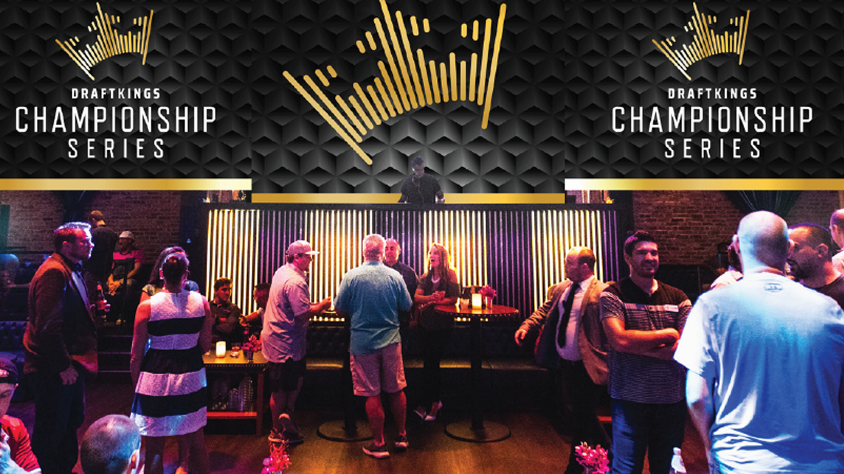 DraftKings Championship Series event space: a black cube-patterned wall with a gold crown and twin logos above a DJ, overlooking a crowded lounge